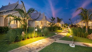 Una hilera de villas de estilo tradicional con tejados de tejas y un camino de jardín bien cuidado que las atraviesa.