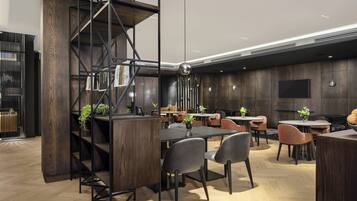 Un restaurante moderno con interior de madera, estanterías de metal negro y varias mesas y sillas.