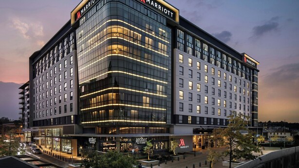 A modern Marriott hotel with a glass facade, multiple floors, and a prominent logo. - Johannesburg Marriott Hotel Melrose Arch (Johannesburg)