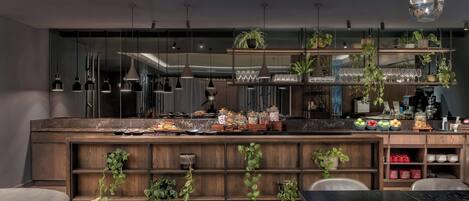 A modern kitchen with wooden shelves, hanging plants, and a variety of food items.
