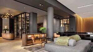 A modern lobby with a reception desk, seating area, and a large column. - Johannesburg Marriott Hotel Melrose Arch (Johannesburg)