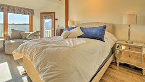 A bedroom with a large bed, bedside tables, a chair, and a view of the outdoors. - Hot Tub & Moat Mtn Views: North Conway Townhouse (North Conway)