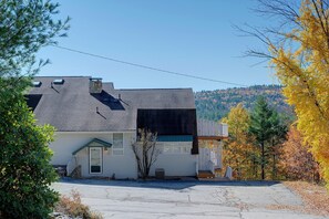 A two-story house with a sloped roof, a front porch, and a garage. - Hot Tub & Moat Mtn Views: North Conway Townhouse (North Conway)