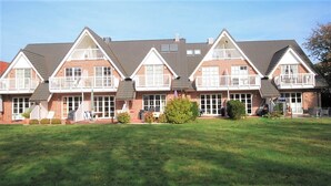 A row of brick houses with white trim and gabled roofs. - Apartment oasis in Dünenhof (St. Peter-Ording)