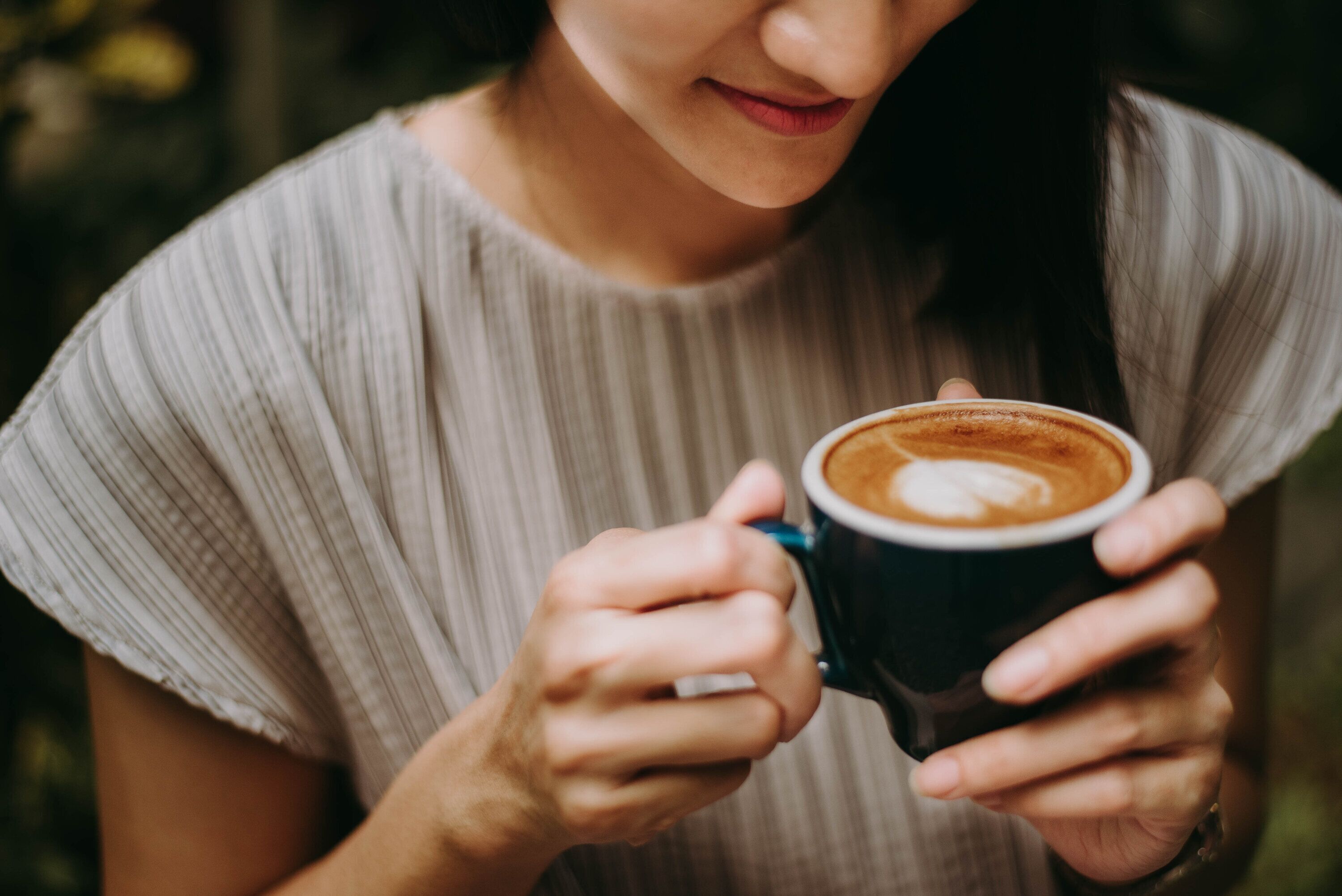 Una persona sosteniendo una taza de café.