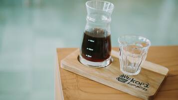 A glass carafe and a glass on a wooden board with a logo.