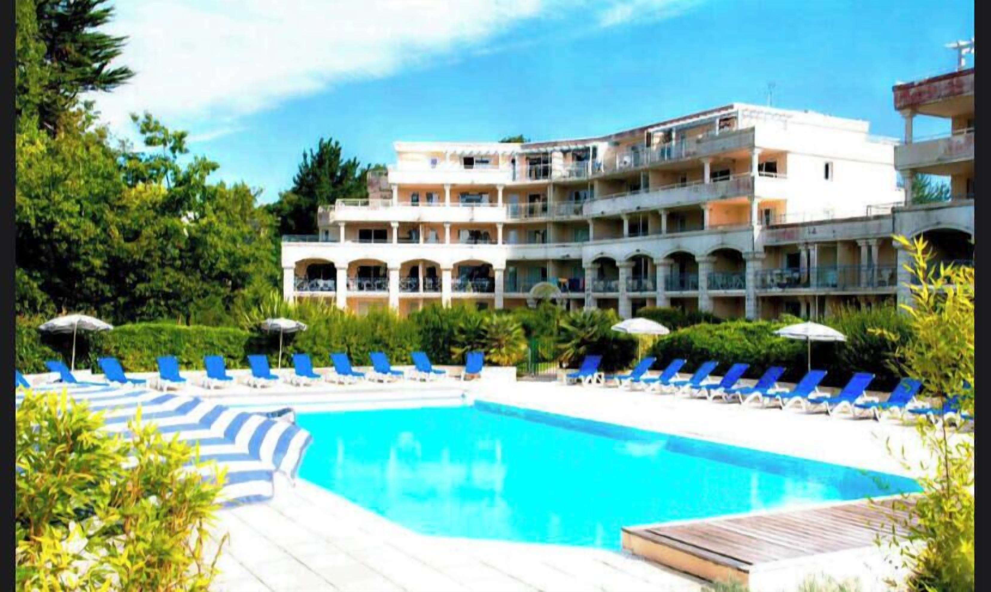 Un hôtel doté d’une piscine, de plusieurs balcons et de chaises longues.