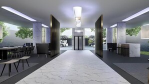 Eine moderne Lobby mit Marmorboden, einer Rezeption und Blick ins Freie.