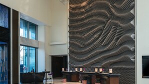 A spacious lobby with a modern design, featuring a unique textured wall, a reception desk, and contemporary seating arrangements. - Renaissance Nanning Hotel (Nanning)