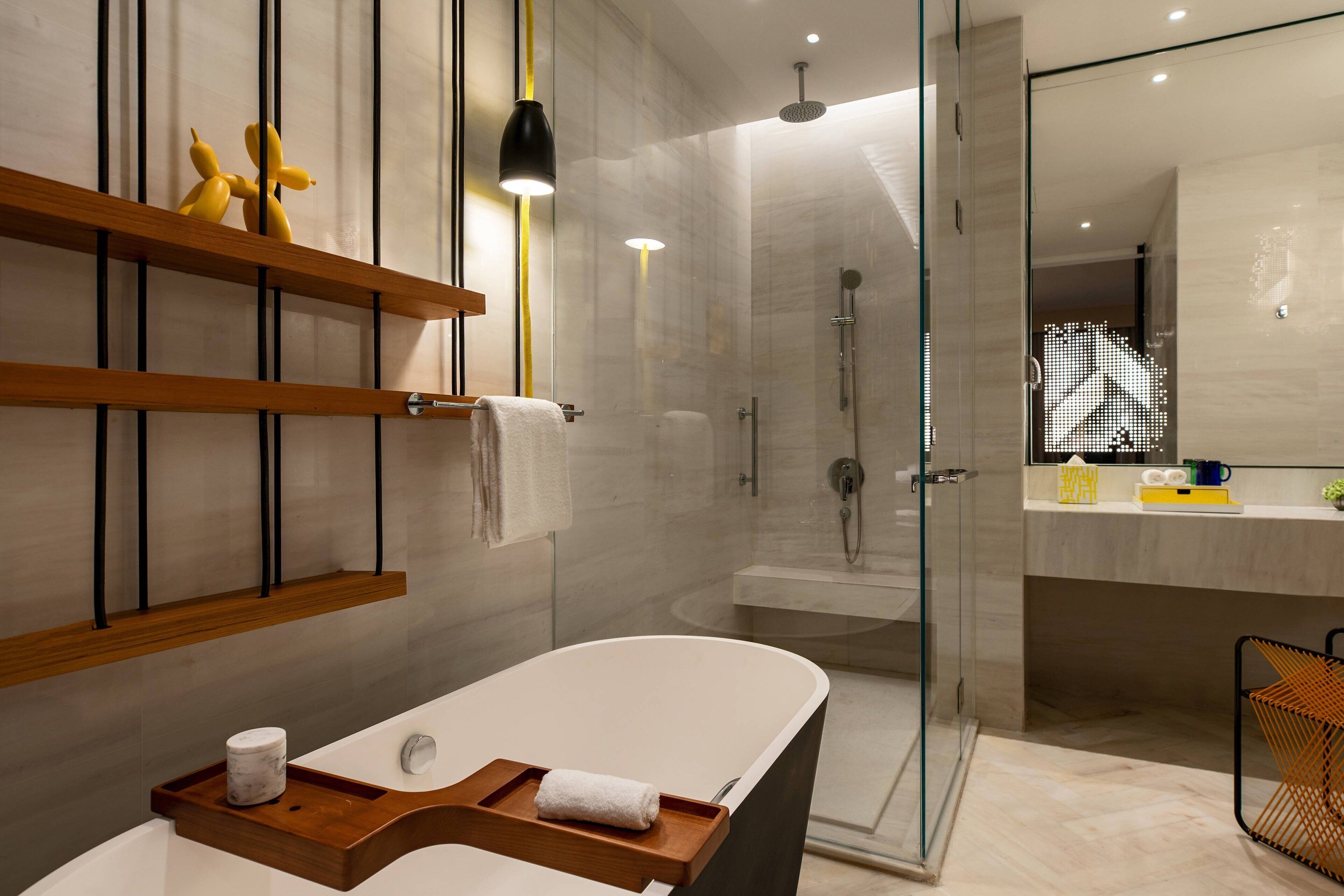 Een moderne badkamer met een vrijstaand bad, een douche met glazen wanden en een wastafelmeubel met spiegel.