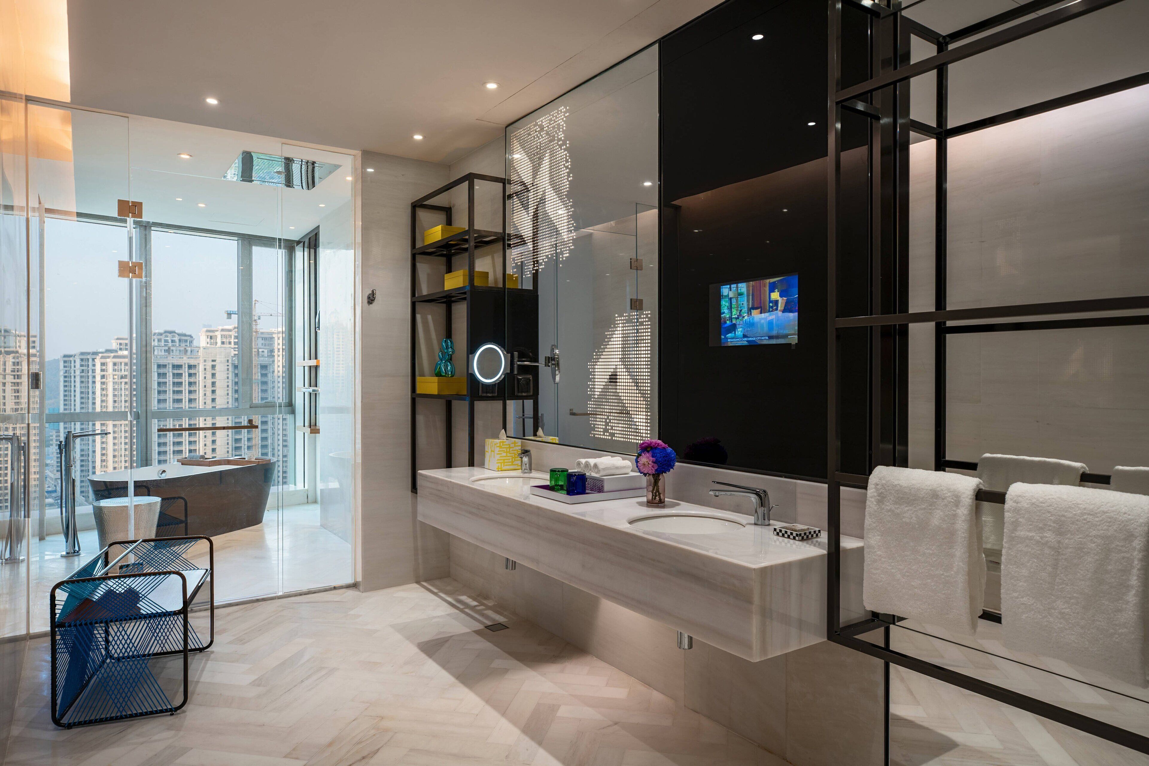 Une salle de bain moderne avec un grand miroir, deux vasques et une baignoire.