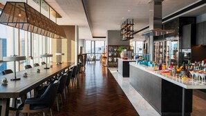 A modern kitchen with a long dining table, bar area, and large windows offering city views. - Renaissance Nanning Hotel (Nanning)
