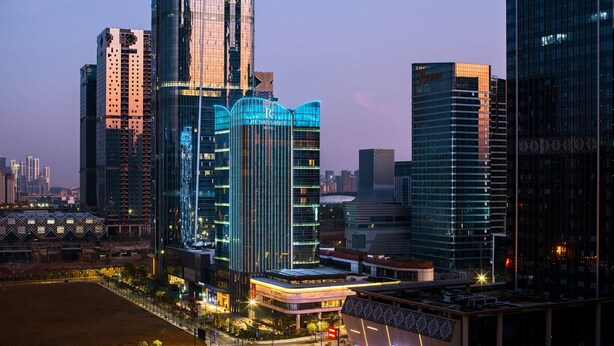 A high-rise hotel with a prominent 'Renaissance' sign, surrounded by other tall buildings and a well-lit urban environment. - Renaissance Nanning Hotel (Nanning)