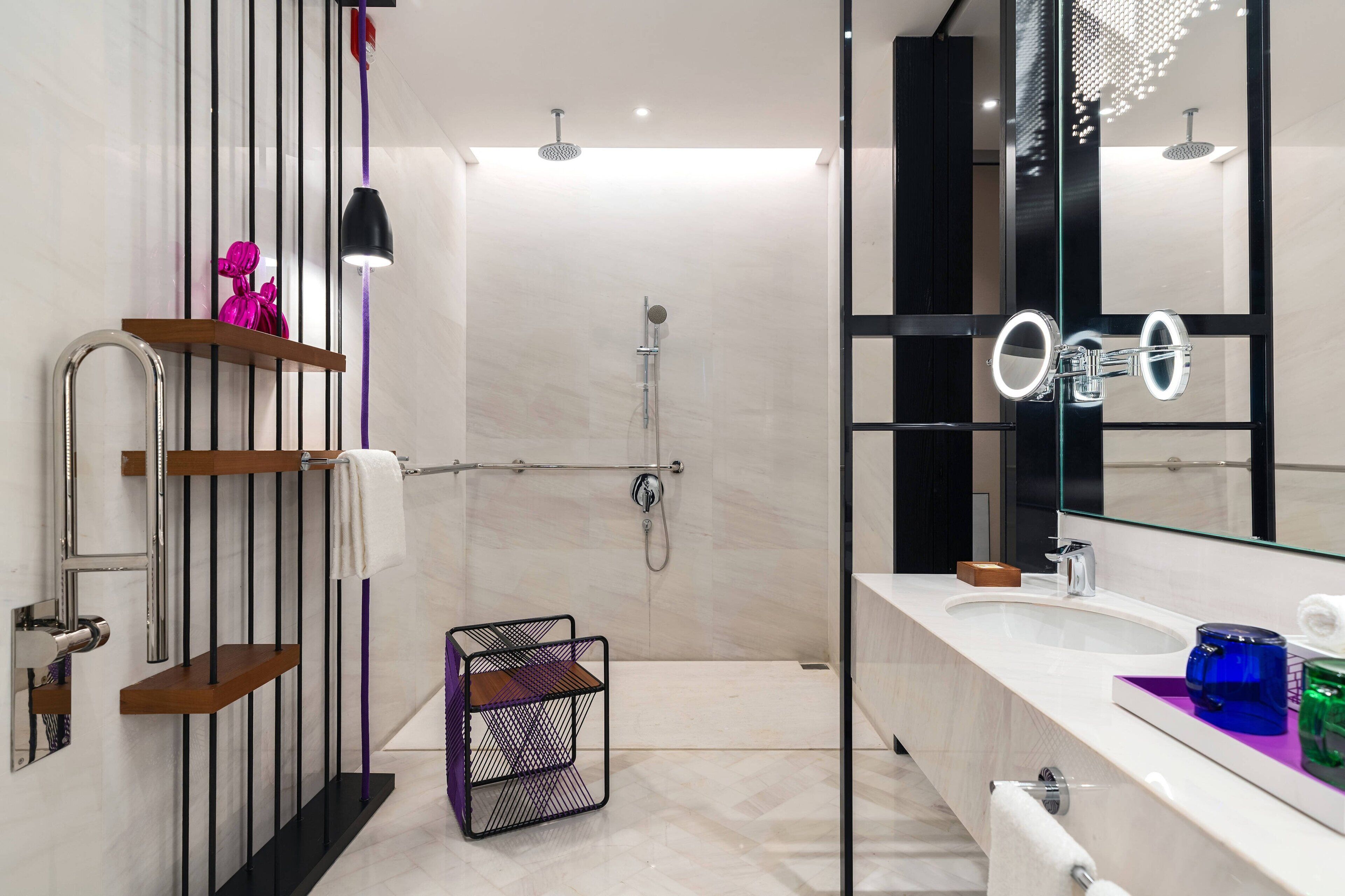 Un baño moderno con ducha, tocador con espejo y perchero para toallas.