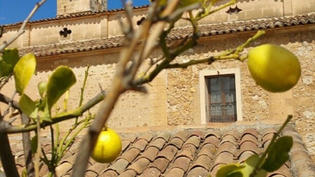 A building with a tiled roof and a tower. - Town house Sant Llorenc, east coast Mallorca, 15 minutes to the beach (Sant Llorenc)