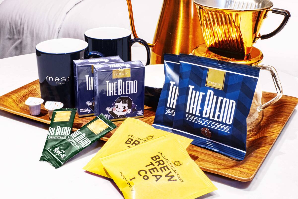 A tray with coffee mugs, tea bags, and a teapot.