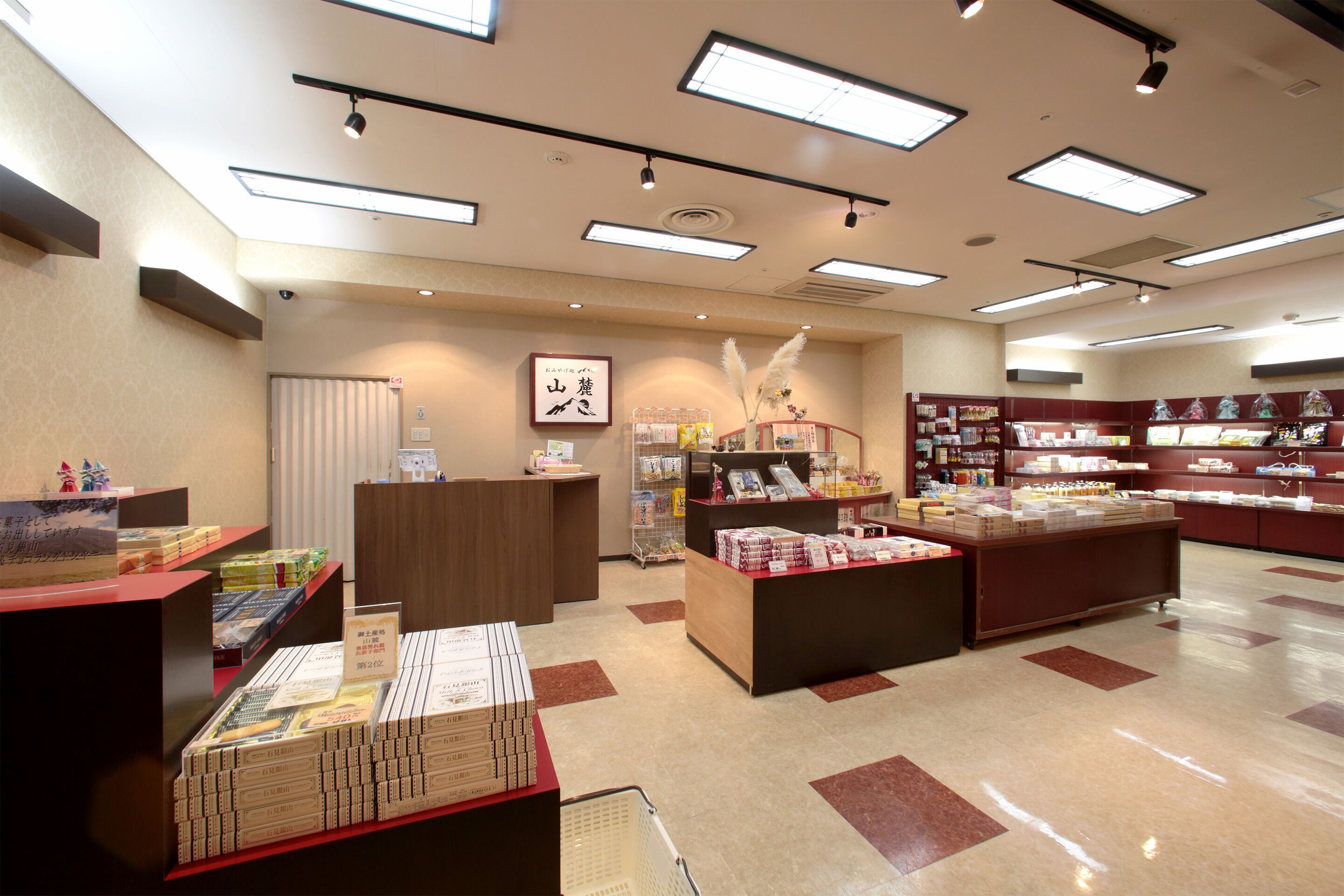 A bookstore with multiple display tables, shelves with books, and a reception area.