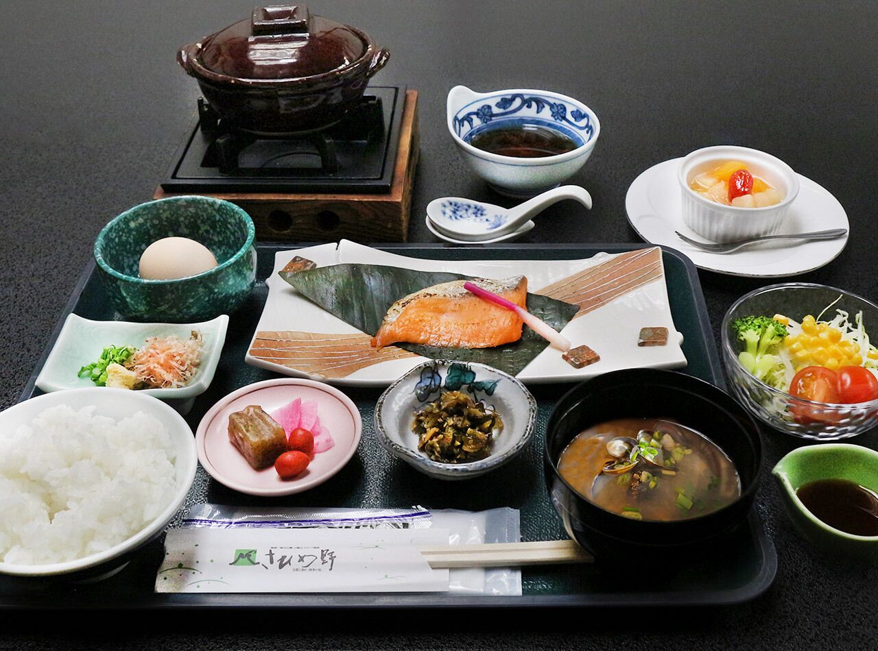 En traditionell japansk måltid med ris, fisk och olika tillbehör, serverad på ett fat.
