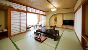 Een traditionele Japanse kamer met tatami vloerbedekking, een lage tafel en glijdende deuren.