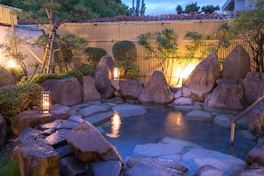 A serene garden with a pond, rocks, and bamboo fencing. - Shiki no yado SAHIMENO (Oda)
