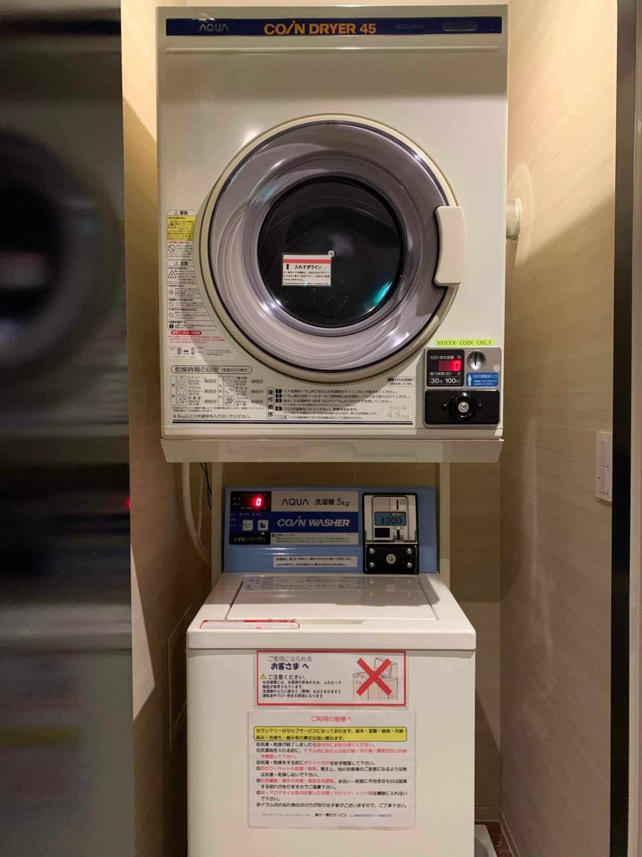 A coin-operated washing machine with a digital display and a coin slot.