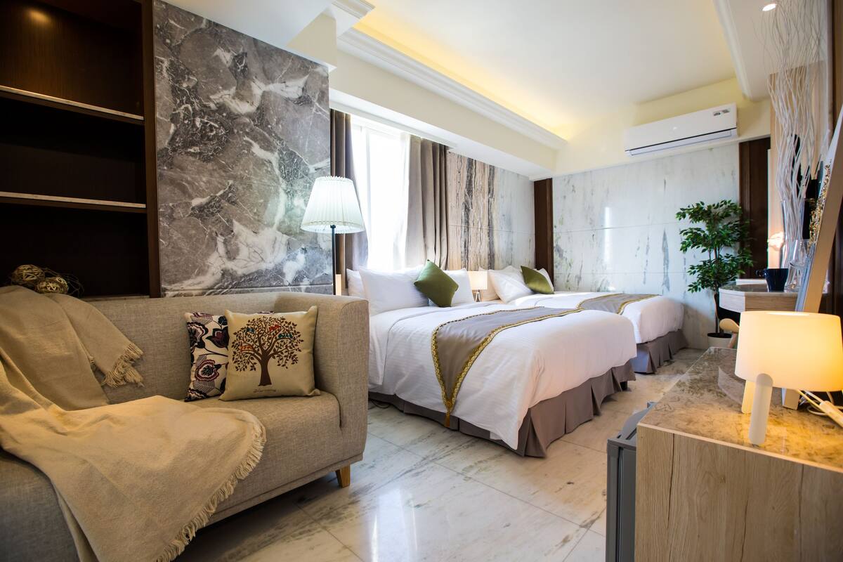 Habitación cuádruple Deluxe | Edredón, camas Tempur-Pedic, escritorio y cortinas blackout