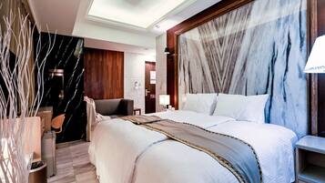 Een moderne hotelkamer met een groot bed, een houten hoofdeinde, een bureau en een stoel.