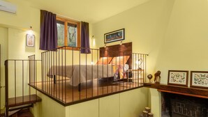 Une chambre avec un lit en mezzanine, une cheminée et un escalier.