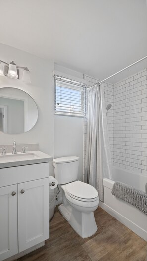 Een bad/douchecombinatie, een haardroger, handdoeken, zeep