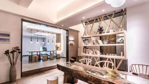 A modern interior with a wooden dining table, chairs, and a bookshelf. - Suzhou Jianluju Inn (Suzhou)