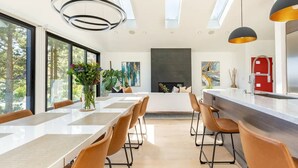A modern kitchen with a central island, large windows, and a fireplace. - Exceptional Hilltop Villa with Panoramic View (SF)