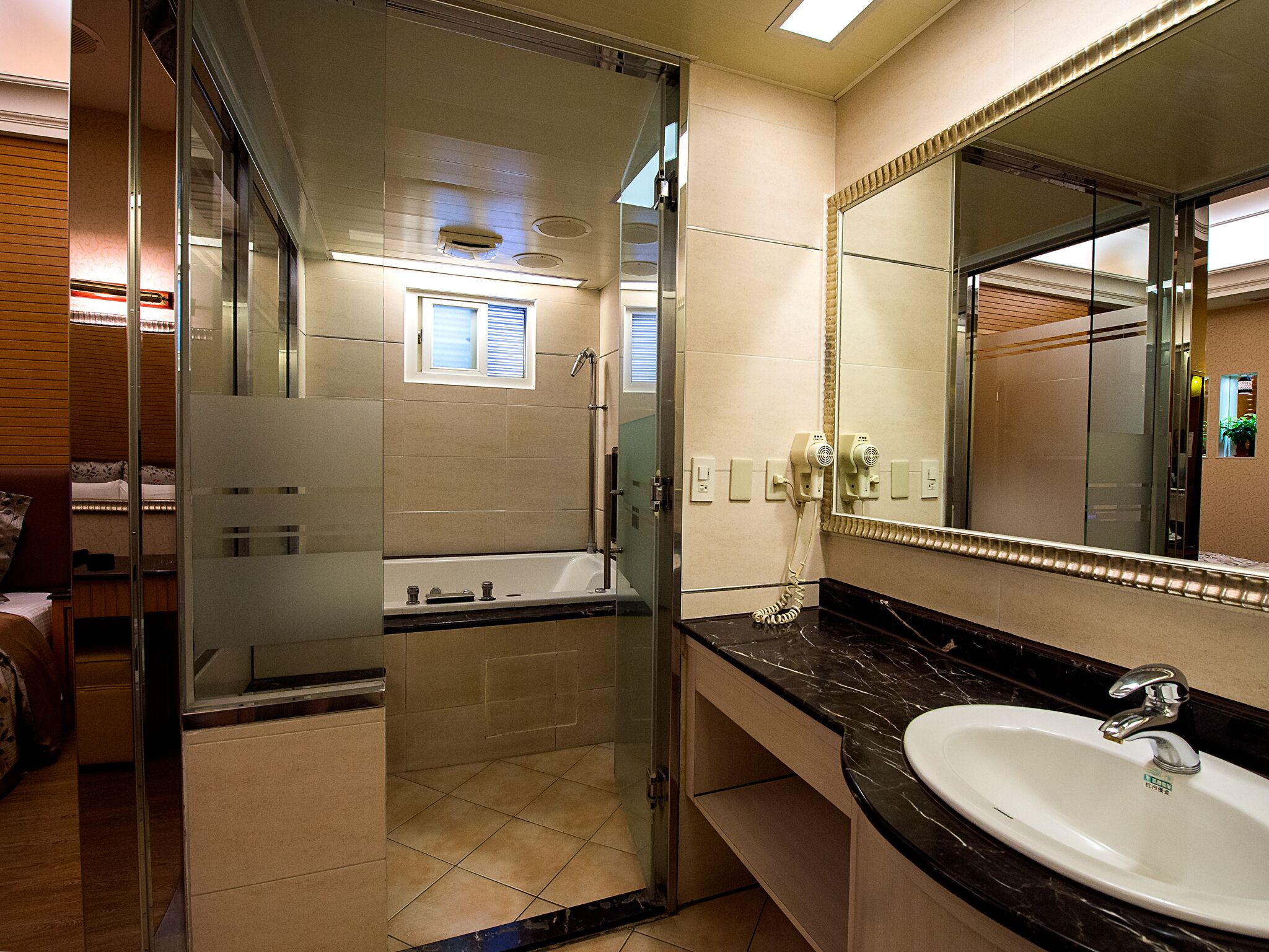 Een moderne badkamer met een douchecabine van glas, een badkuip, een wastafelmeubel met een wastafel en een grote spiegel.
