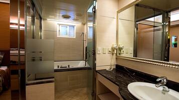 Een moderne badkamer met een douchecabine van glas, een badkuip, een wastafelmeubel met een wastafel en een grote spiegel.