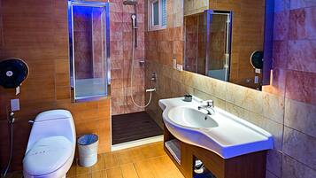 A modern bathroom with a shower, toilet, and sink.