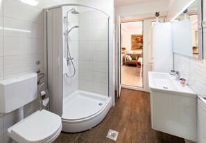 Un baño moderno con ducha, inodoro y lavamanos.