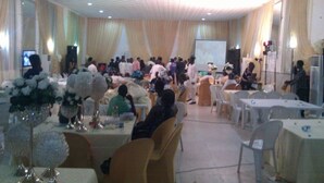 A banquet hall with round tables, chairs, and floral centerpieces. - Rita Lori Hotel Lagos (Lagos)