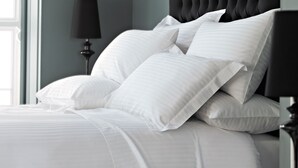 A neatly made bed with white linens and a black headboard. - Rita Lori Hotel Lagos (Lagos)
