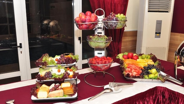 A buffet table with various food items including fruits, vegetables, and cheeses. - Paconsu Suites (Calabar)