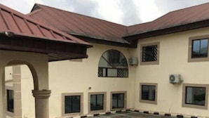 A building with a symmetrical facade, multiple windows, and a central archway. - Paconsu Suites (Calabar)