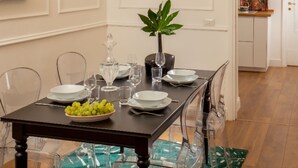 A dining table set with clear glassware, plates, and a bowl of grapes. - Daplace - Flaminia Apartment (Rome)