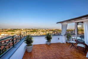 A terrace with potted plants, a table, and chairs. - Daplace - Terenzia Apartment (Rome)