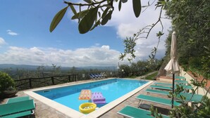 A swimming pool with lounge chairs and a view of the mountains. - Arcobaleno (Loro Ciuffenna)