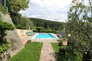 Une piscine avec des chaises longues et un chemin de pierre menant à celle-ci.