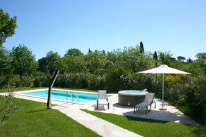 A backyard with a swimming pool, two lounge chairs, a hot tub, and a patio umbrella. - Casa Cervognano (Montepulciano)