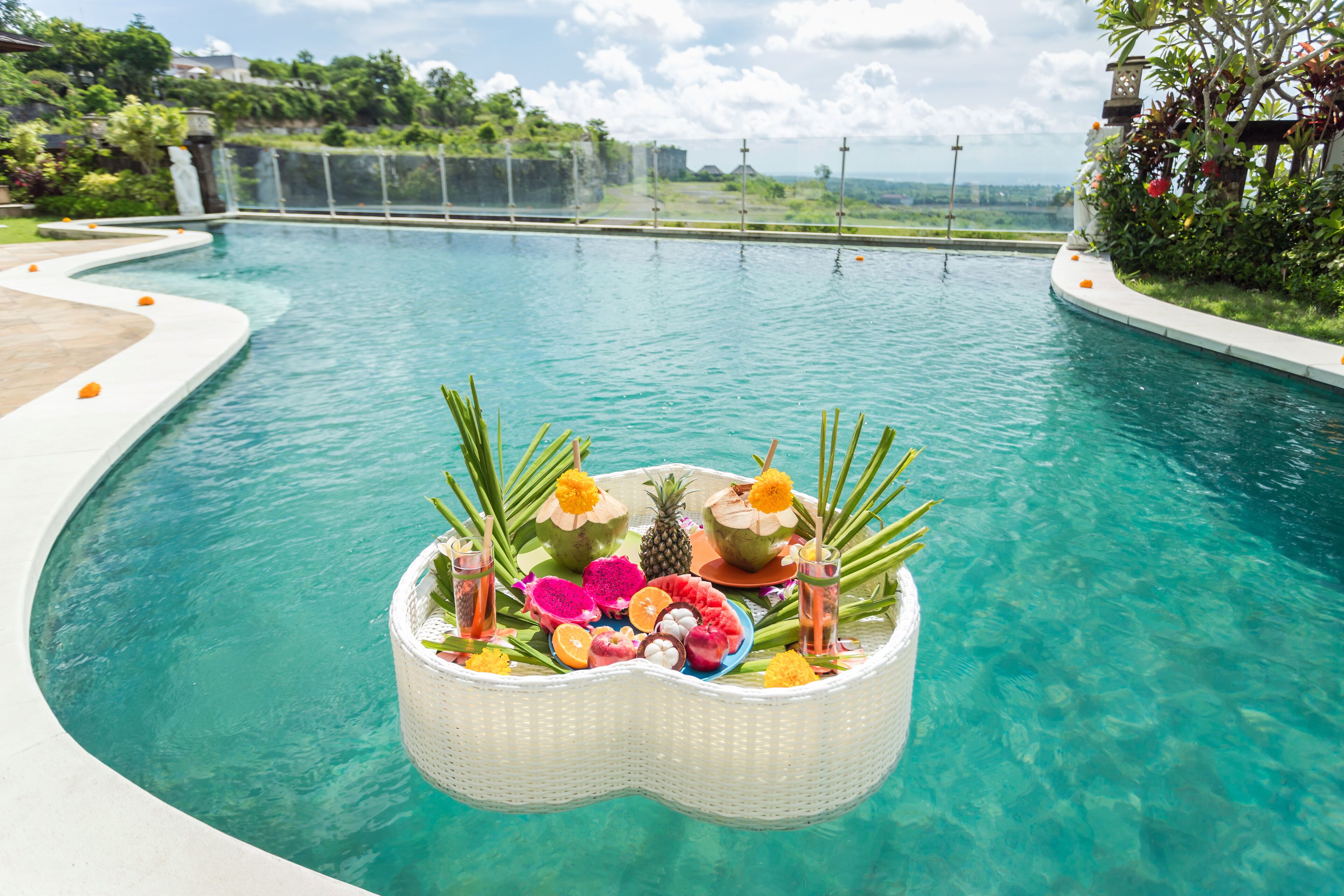 Una piscina al aire libre, sombrillas, sillones reclinables de piscina