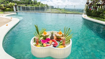 Una piscina al aire libre, sombrillas, sillones reclinables de piscina