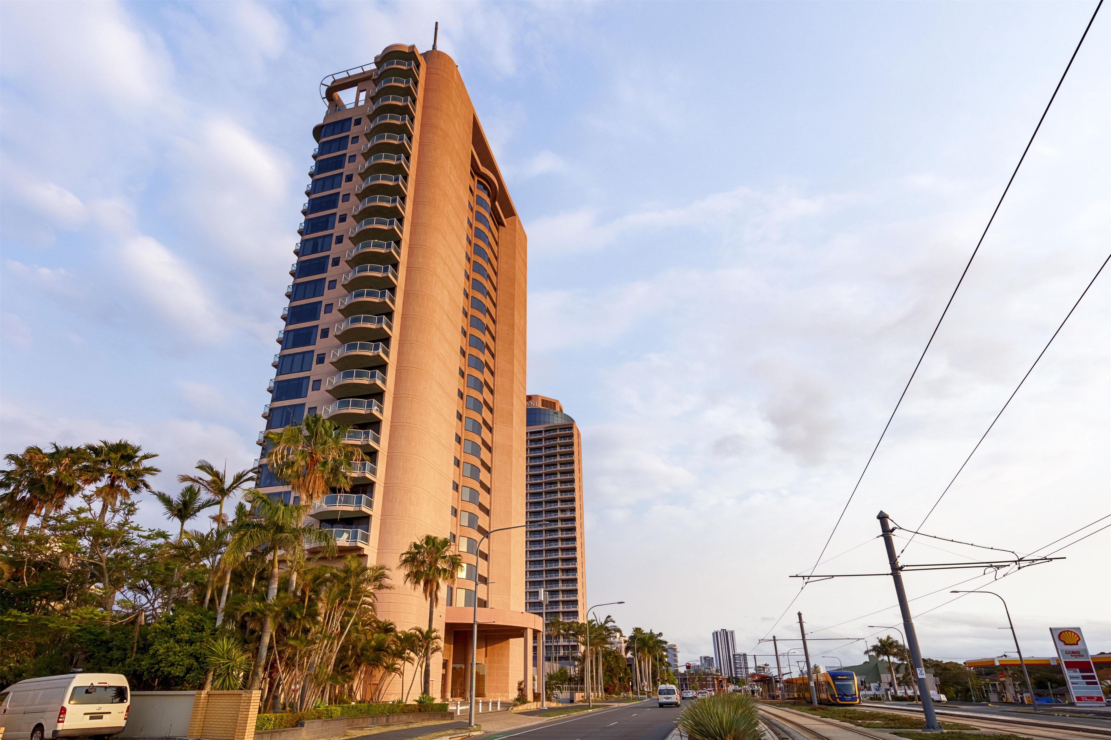 A high-rise building with multiple balconies and a curved facade.