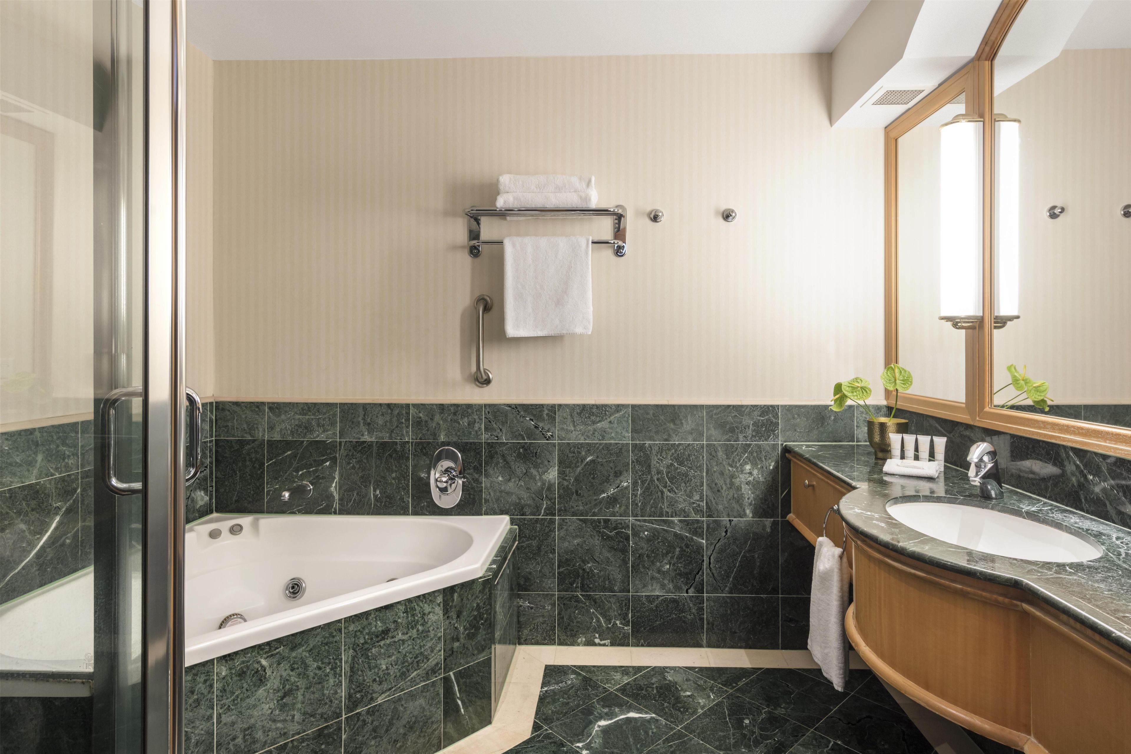 A modern bathroom with a bathtub, a sink, and a shower.