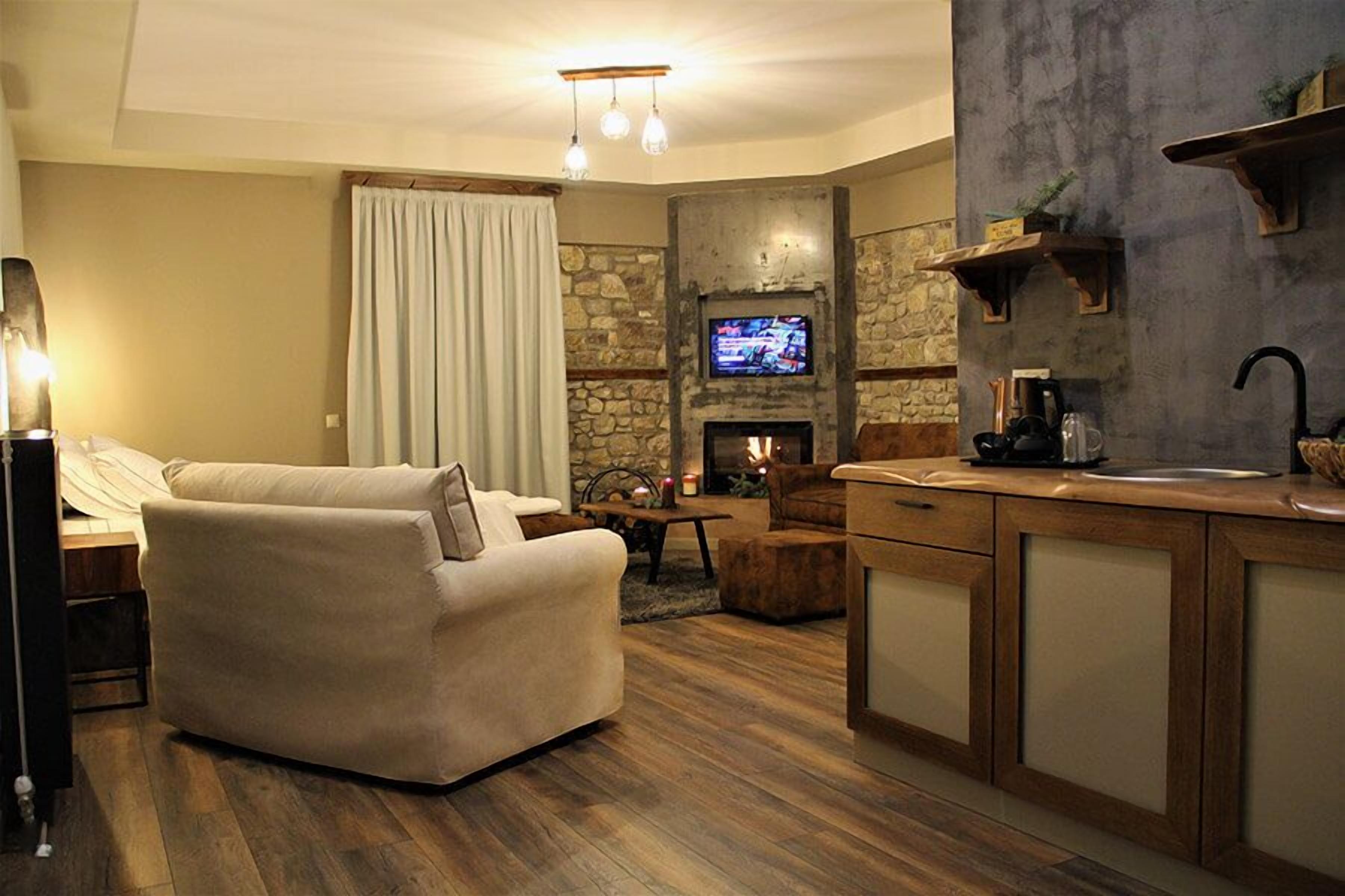 Un salon confortable avec une cheminée, un canapé et un téléviseur.