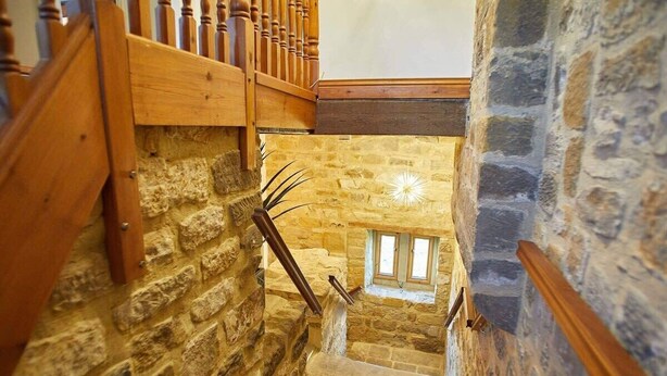 A stone staircase with wooden railings and a small window at the top. - Host & Stay | The Coach House (Whitby)